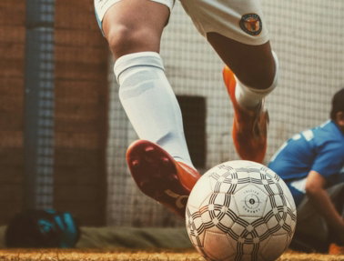 person in white and red soccer jersey kicking soccer ball